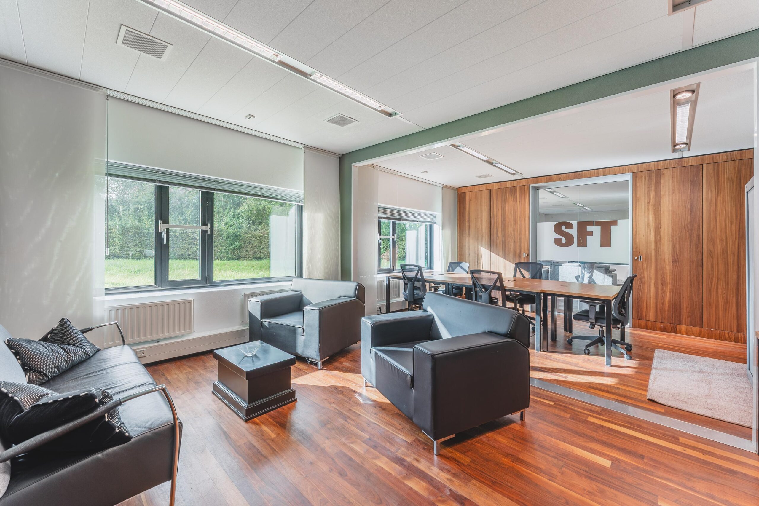 Moderne kantoorruimte aan de Prof. W.H. Keesomlaan met zithoek, vergadertafel en houten vloer.